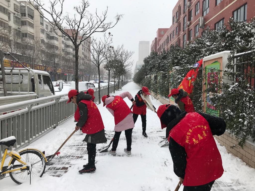 志愿者们迎着雪花继续干