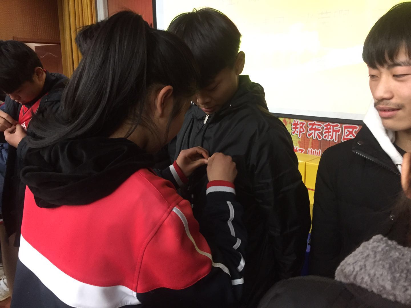 老团员为新团员佩戴团徽