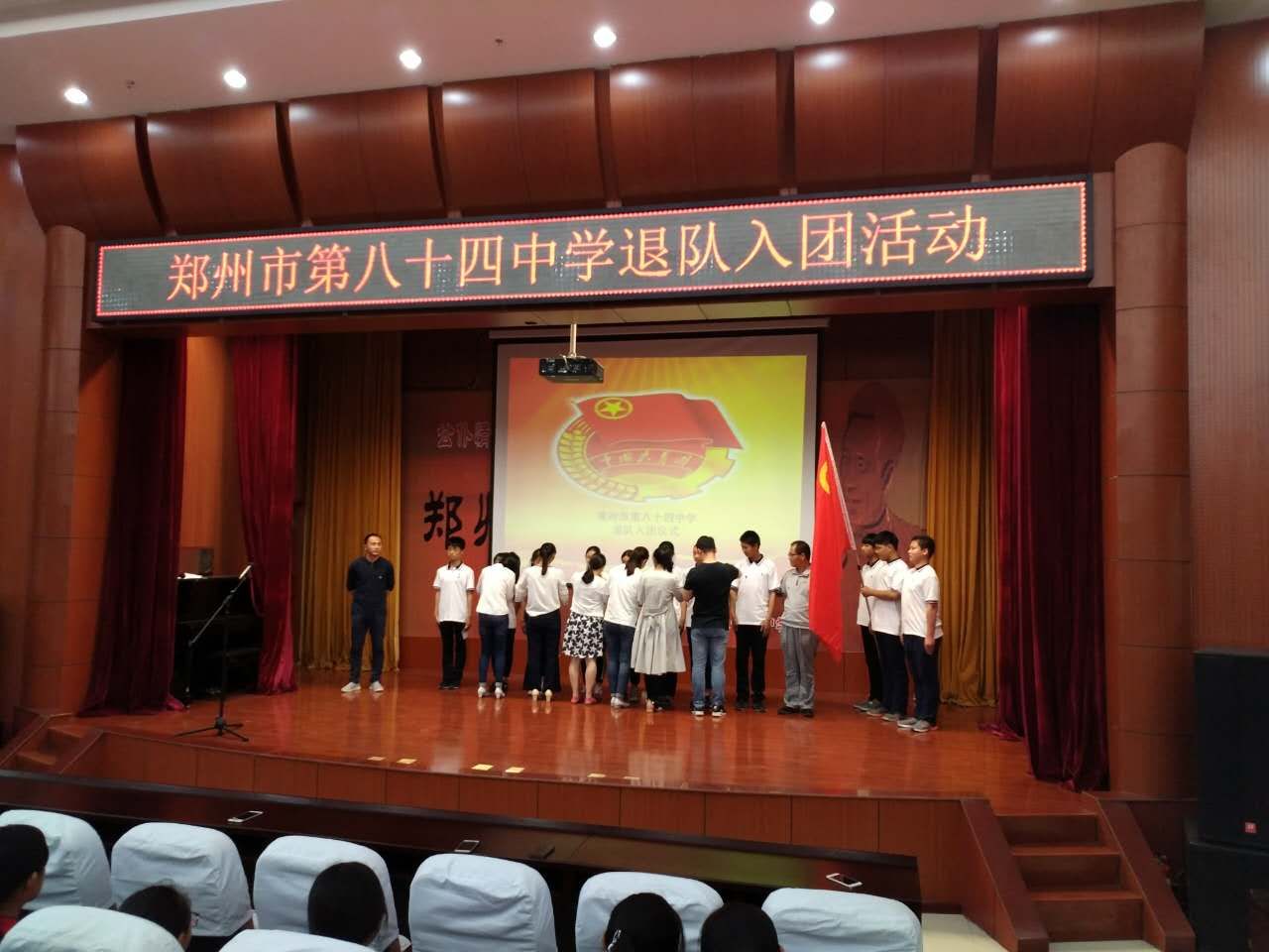 学校领导和老师为新团员佩戴团徽