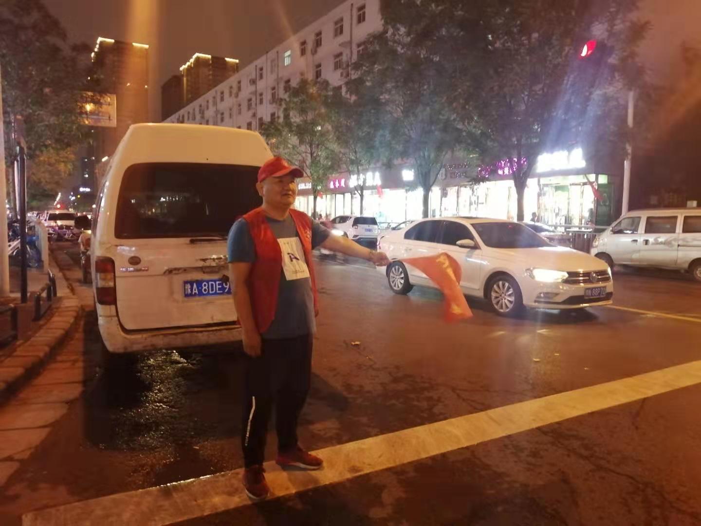 19点蒙蒙细雨中,志愿者仍在雨中坚守