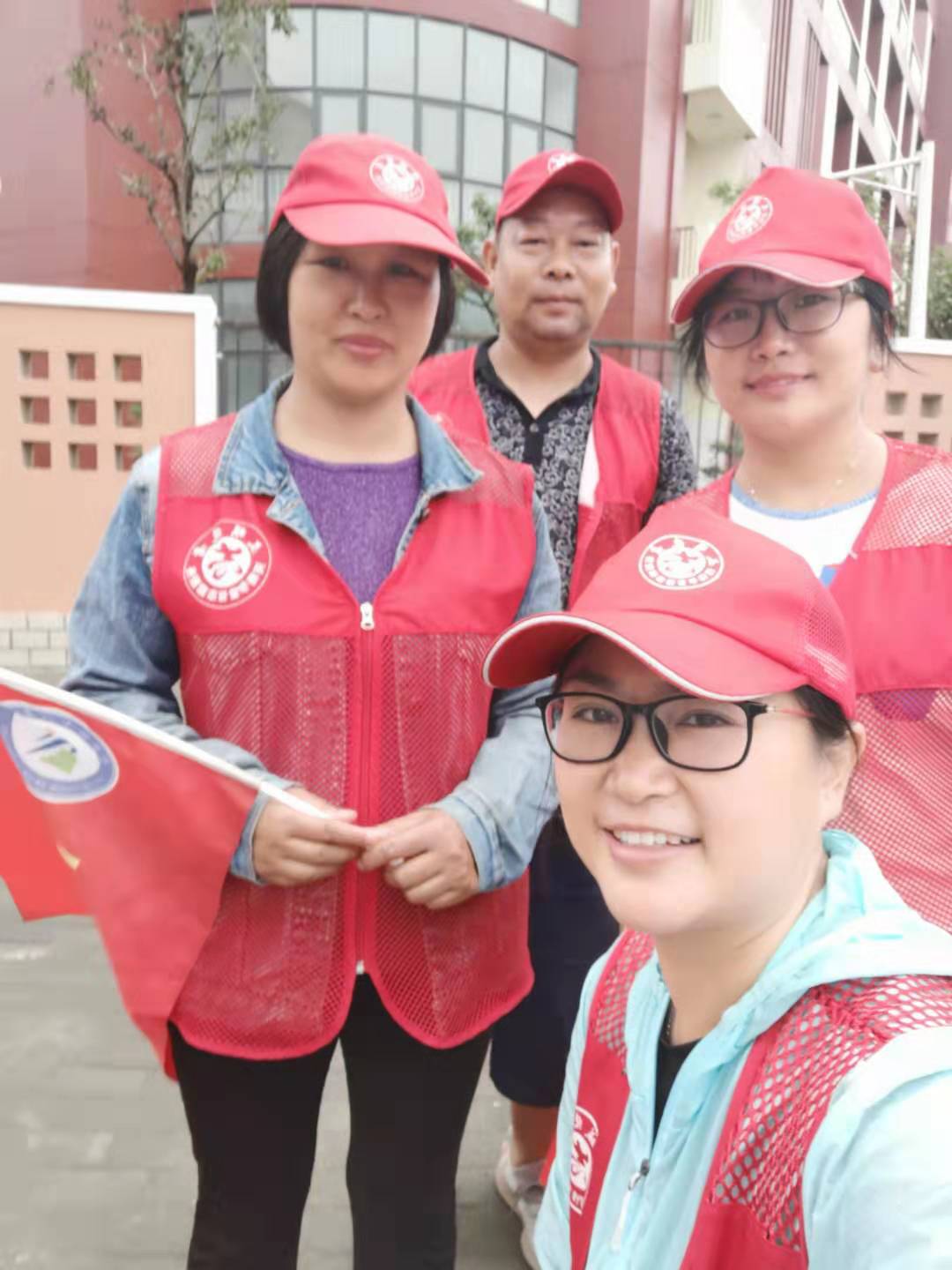 中午,秋雨暂停,家长和教师作为志愿者到路口引导市民文明出行